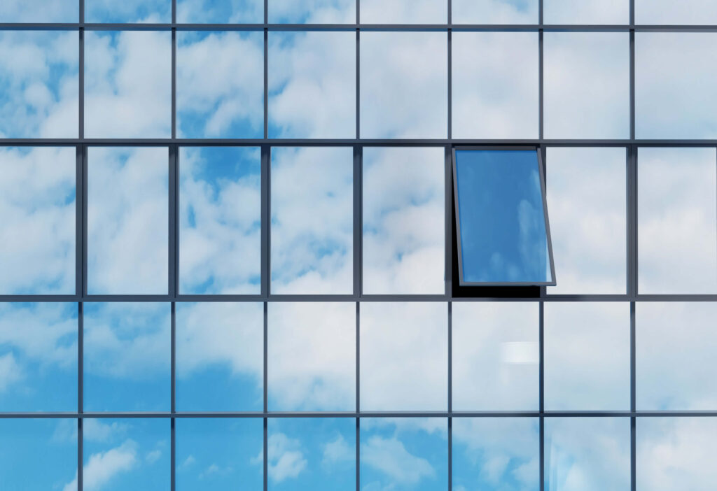 Fenêtre d'immeuble ouverte avec ciel bleu